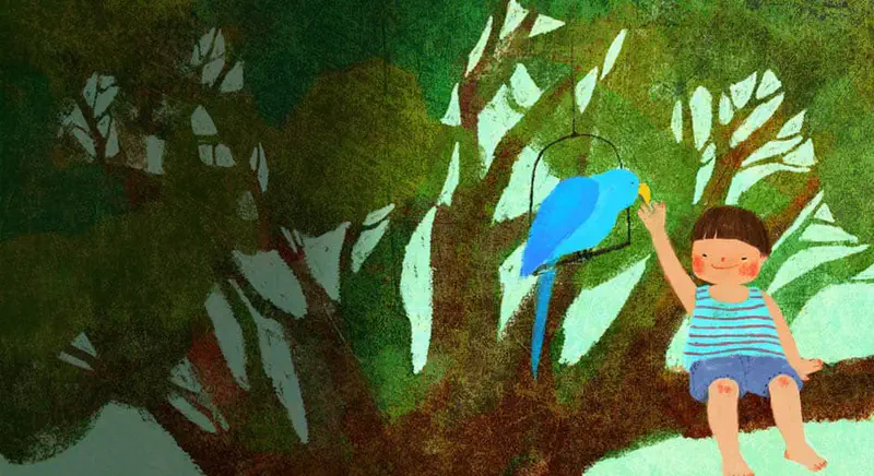 Happy boy sitting on tree branch petting blue parrot Butter in lush green garden