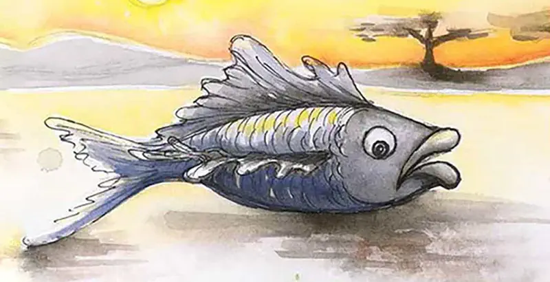 A gray fish with yellow stripes lying on sand at sunset with a tree silhouette in the background.