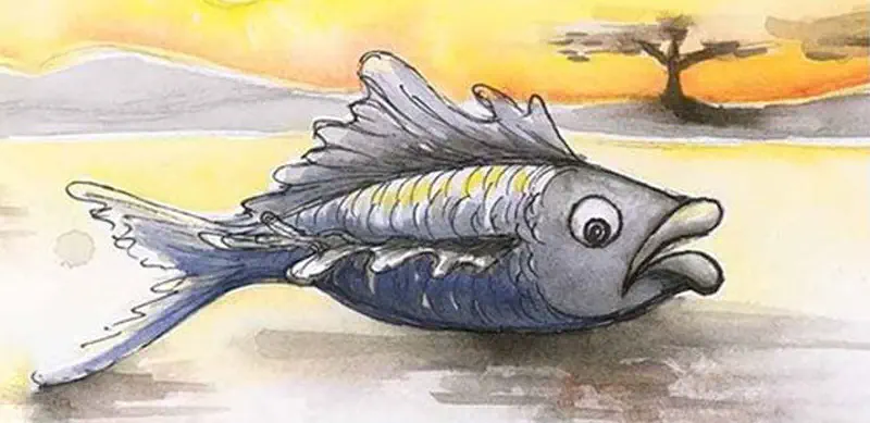 A gray fish with yellow stripes flopping on sand at sunset with mountains and a tree in the distance.