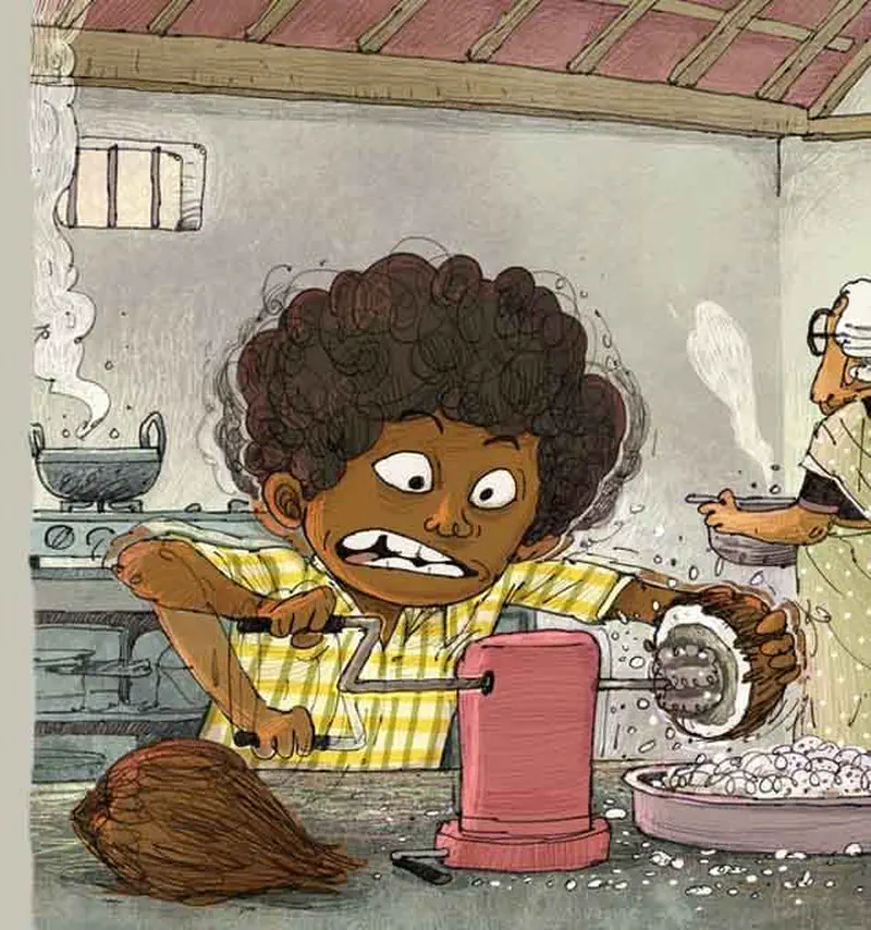 A boy scrapes coconut flesh using a grater in a kitchen while grandmother cooks at the stove in the background.