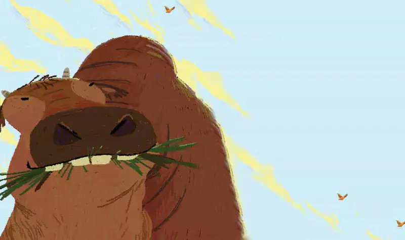 Close-up of a large brown water buffalo chewing grass with yellow sunlight streaming behind it and small birds flying in the sky.