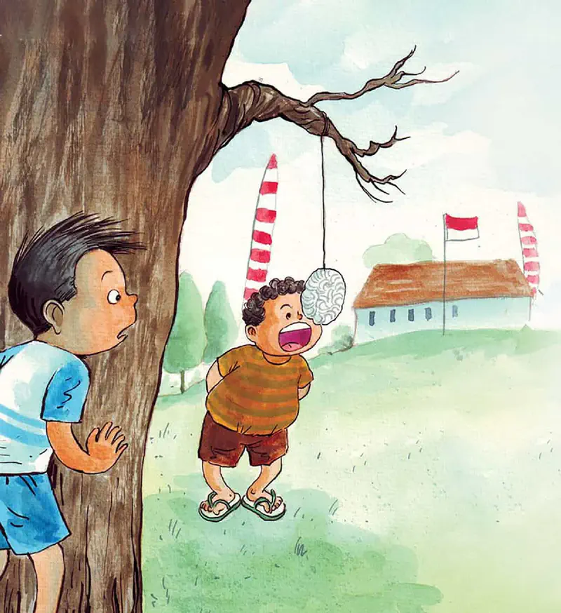 Boy watches another boy eating a hanging kerupuk cracker near a tree with Indonesian flags and red-white poles in the background.