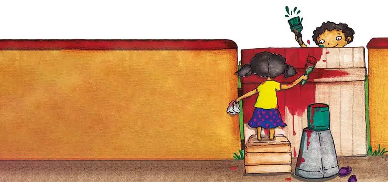 Two children paint a wooden gate red. A girl stands on a crate while a boy peeks over the top holding a green brush.