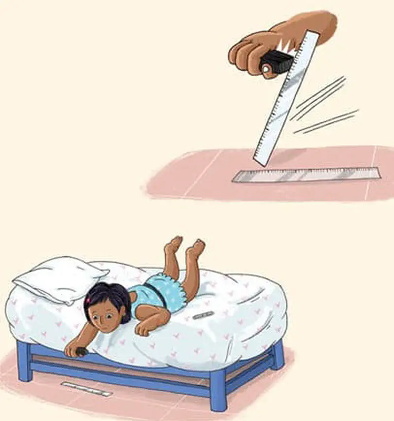 A hand holds a magnet attracting a metal ruler. Below, a girl lies on a bed reaching toward the floor looking worried.