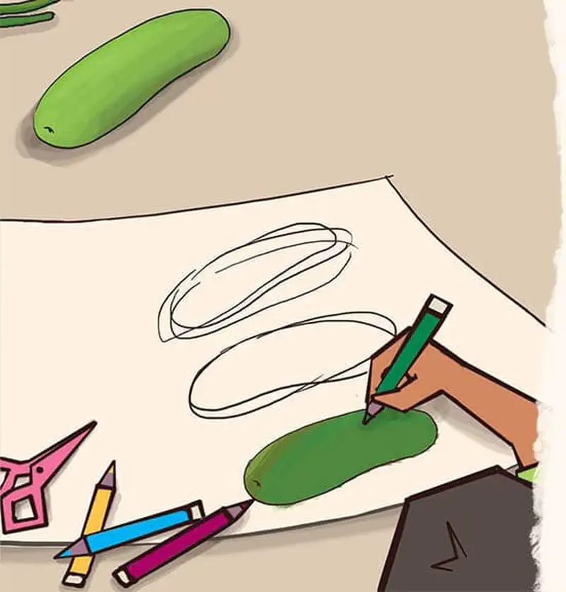 Hand coloring cucumber drawing with green pencil, scissors and colored pencils on table.