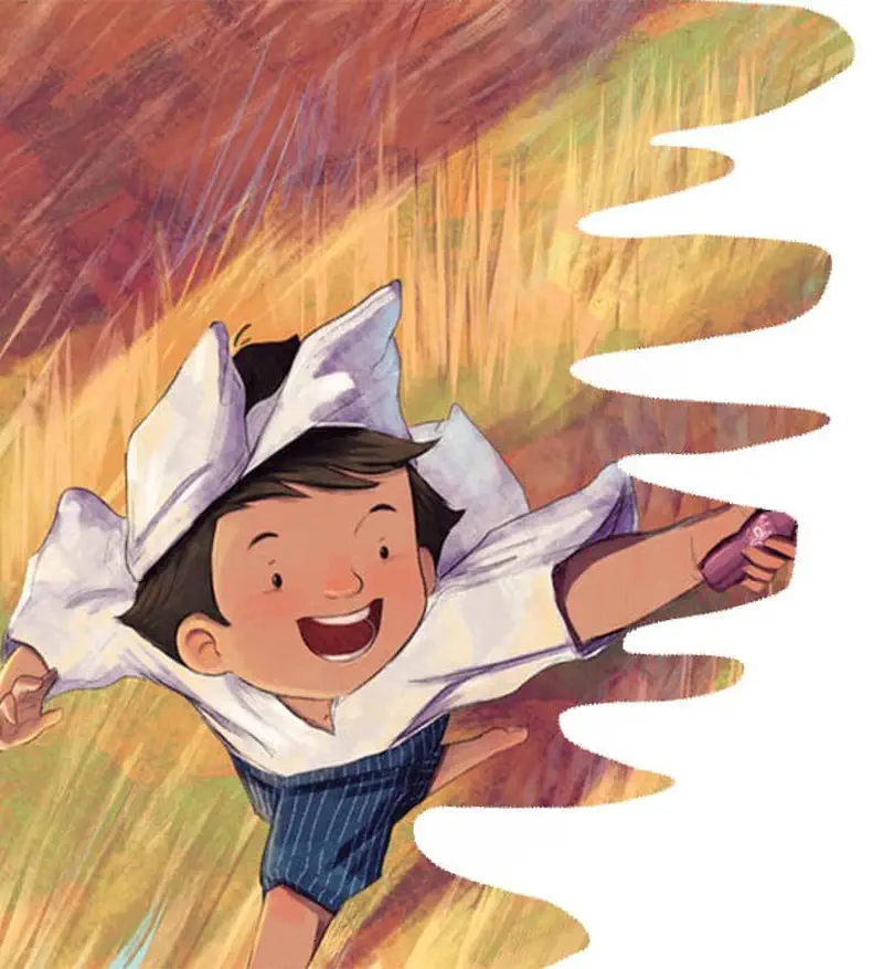 Happy boy running through golden field with arms outstretched wearing white shirt and blue shorts.