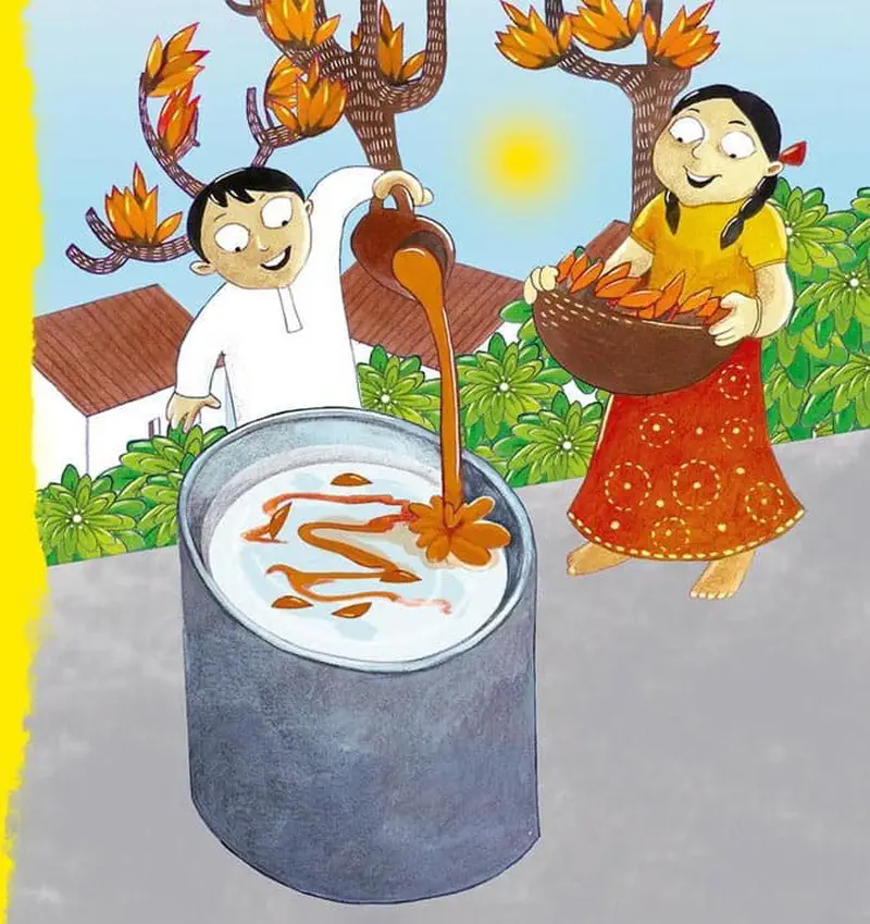 A boy pours orange Holi color into a large metal container while a girl in a yellow top and red skirt carries a basket of orange flowers.