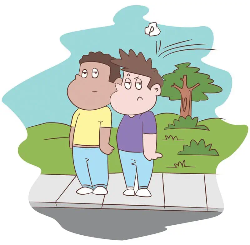 Two boys walk on a sidewalk looking annoyed as a crumpled piece of trash flies past their heads from behind.