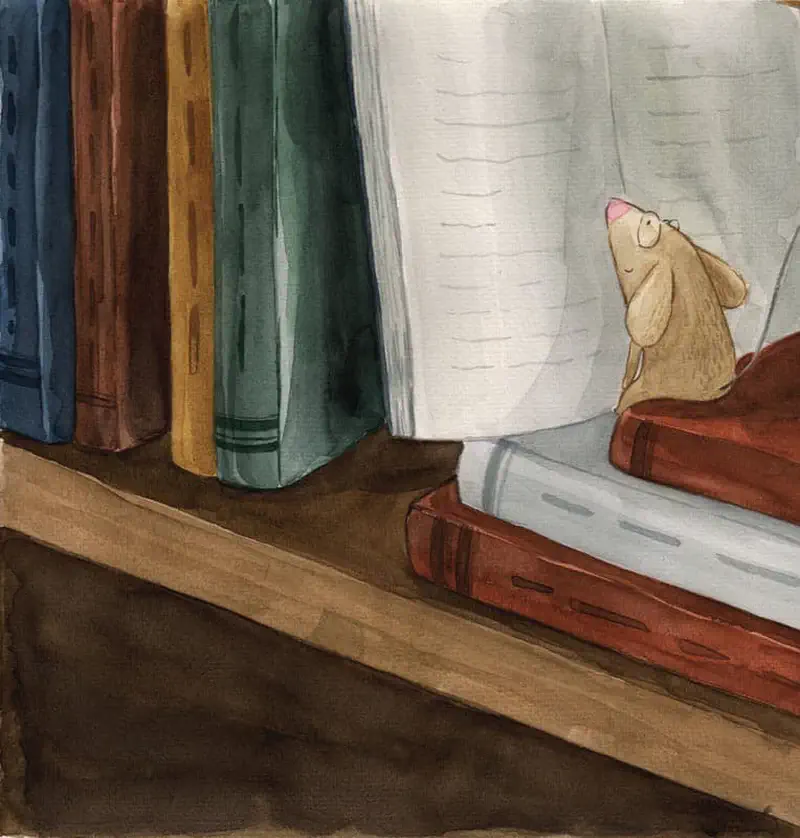 A small brown mouse with pink ears sits contentedly on a stack of books reading an open book on a wooden bookshelf.