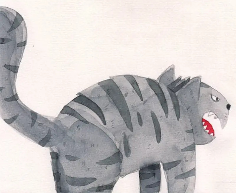 An angry gray striped cat with sharp teeth hisses aggressively with its fur bristled and tail raised high.