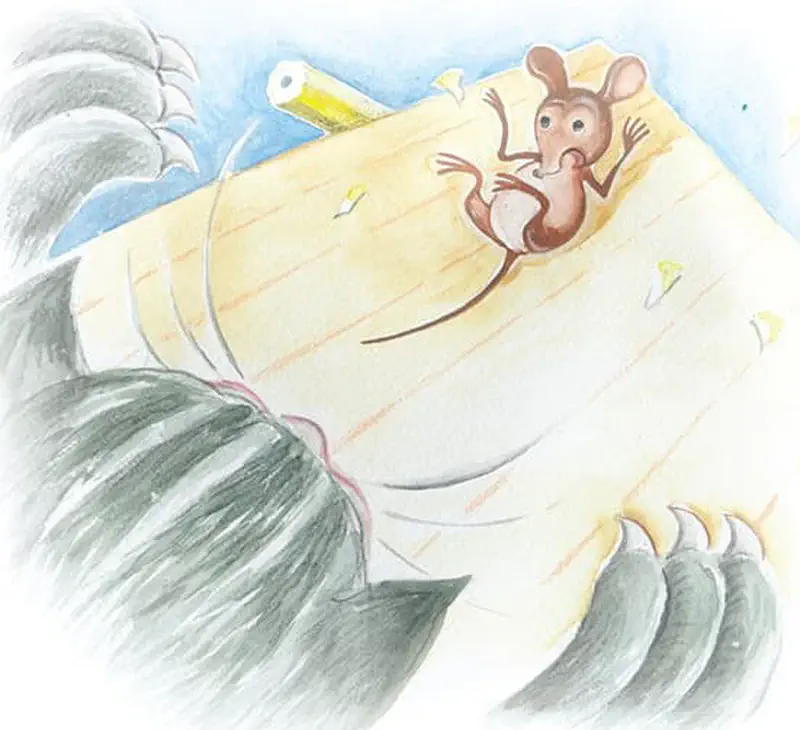 A frightened brown mouse slides down a wooden desk surface as a large gray cat's paws reach menacingly from below.