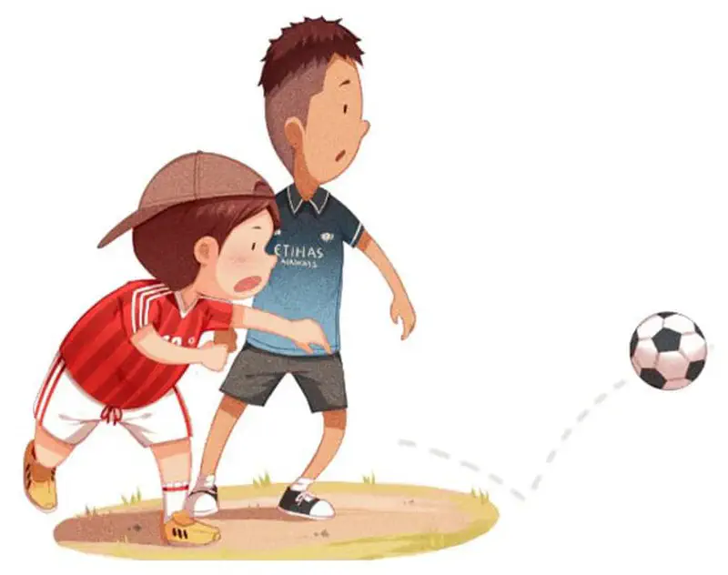 A boy in a red jersey and cap watches as a taller boy in a blue Etihad jersey kicks a soccer ball on a field.
