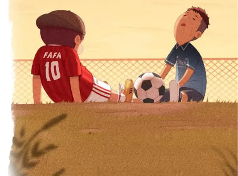 Two boys sit back to back on the ground with a soccer ball between them, one wearing a red Fafa 10 jersey and one in blue.