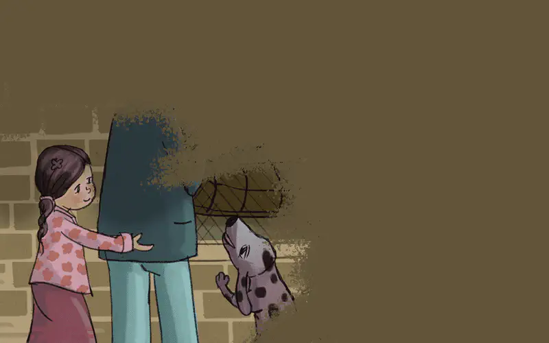 A young girl with braided hair in a pink floral shirt reaches toward a spotted dog who lifts its paw in greeting near a brick wall.